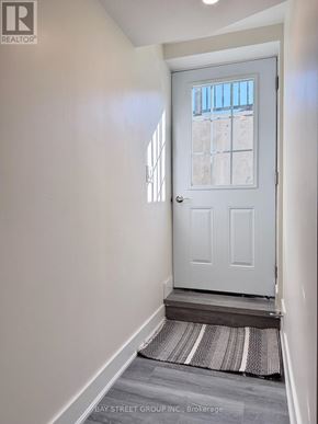 East Gwillimbury (Sharon) apartment for rent - A white door with a glass window is in a hallway with a striped rug on the floor.
