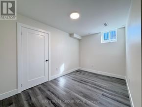 East Gwillimbury (Sharon) apartment for rent - A room with a wooden floor and a window with white blinds.