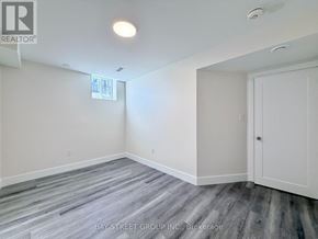East Gwillimbury (Sharon) apartment for rent - A room with a wooden floor and white walls, with a window and a door.