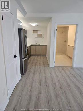 Windsor condo for rent - A kitchen with white cabinets and a refrigerator.