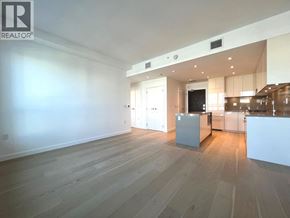 Vancouver apartment for rent - A spacious room with wooden flooring and a kitchen area in the background.