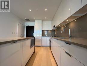 Vancouver apartment for rent - A modern kitchen with white cabinets and a wooden floor.