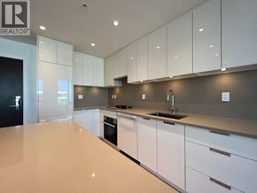 Vancouver apartment for rent - A modern kitchen with white cabinets and a large island.