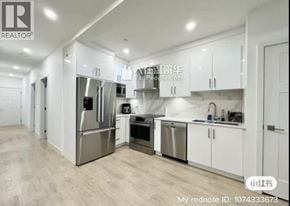 Vancouver townhouse for rent - A modern kitchen with white cabinets and stainless steel appliances.