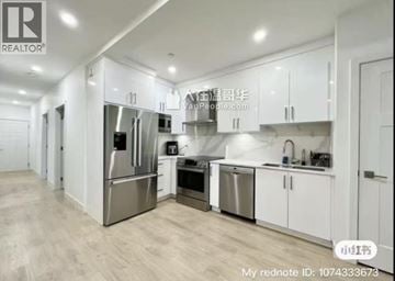 Vancouver townhouse for rent - A modern kitchen with white cabinets and stainless steel appliances.