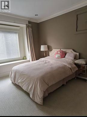Richmond apartment for rent - A bed with a white comforter and pink pillows sits in a room with a window.