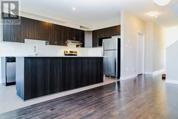 Ottawa townhouse for rent - A modern kitchen with dark wood cabinets and stainless steel appliances.