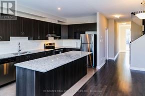 Ottawa townhouse for rent - A modern kitchen with dark wood cabinets and stainless steel appliances.