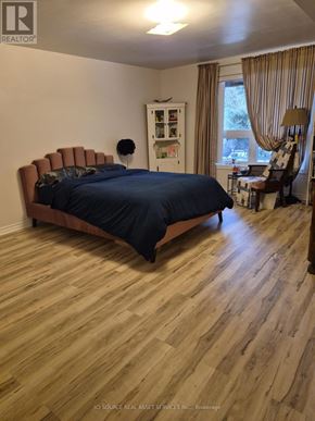 Guelph (Pineridge/Westminster Woods) apartment for rent - A bedroom with a bed, chair, and cabinet.