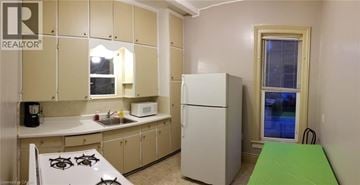 Chatham apartment for rent - A small kitchen with a white fridge and a green table.