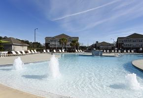 Midway Park apartment for rent - a large pool with water fountains in front of apartment buildings