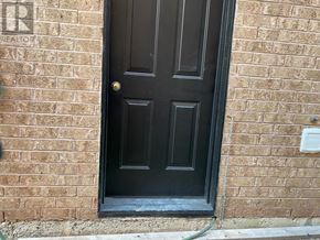 Mississauga (Central Erin Mills) apartment for rent - A black door with a gold handle is set in a brick wall.