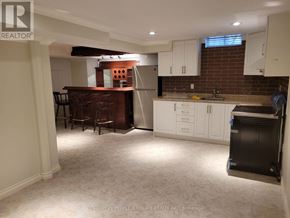 Mississauga (Central Erin Mills) apartment for rent - A kitchen with white cabinets and a brick wall.