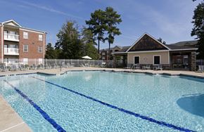 Greenville apartment for rent - A large swimming pool with blue water and a building in the background.