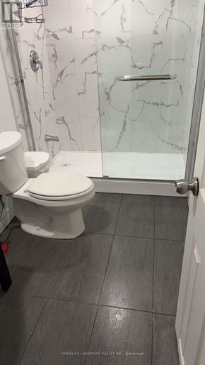 Toronto (L'amoreaux) apartment for rent - A white toilet in a bathroom with a marble wall.