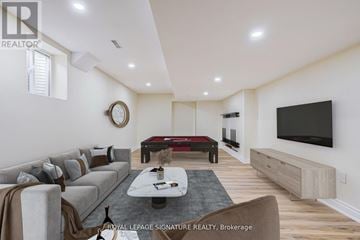 Milton (Co Coates) multi-family for rent - A living room with a grey sofa and a black television.