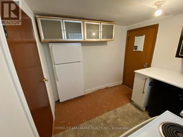 Toronto (East York) apartment for rent - A small kitchen with a refrigerator, cabinets, and a stove top oven.