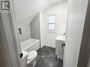 Port Colborne (East Village) fourplex for rent - A white bathroom with a toilet, tub, and sink.