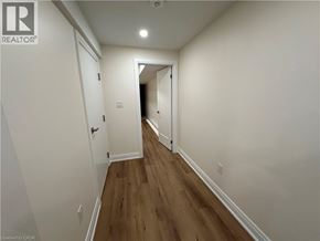 Hamilton apartment for rent - A long hallway with white walls and wood flooring.