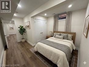 Hamilton apartment for rent - A bedroom with a large bed and a plant in a pot.