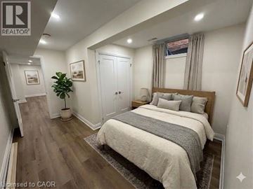 Hamilton apartment for rent - A bedroom with a large bed and a plant in a pot.