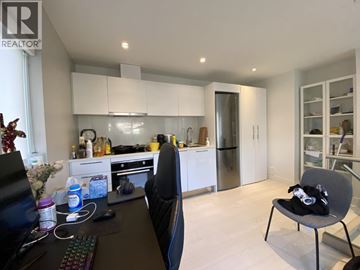 Vancouver apartment for rent - A modern kitchen with a black chair and a desk with a computer.
