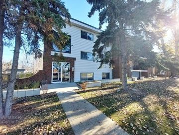 Edmonton apartment for rent - A white house with a tree in front of it.