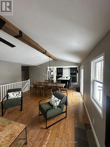 Blue Mountains apartment for rent - A living room with a green chair and a wooden floor.