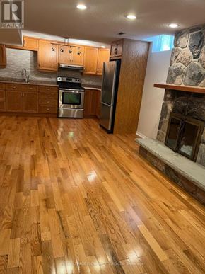 Whitby (Blue Grass Meadows) apartment for rent - A kitchen with wooden floors and a stone fireplace.