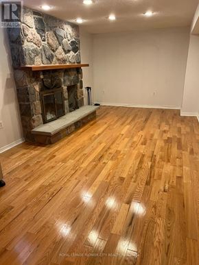 Whitby (Blue Grass Meadows) apartment for rent - A room with a stone fireplace and wooden flooring.