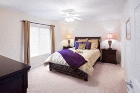 Fort Wayne apartment for rent - A bedroom with a bed, nightstands, and a ceiling fan.