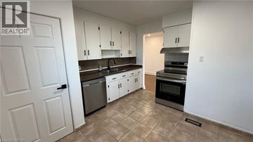 Newmarket apartment for rent - A kitchen with white cabinets and a tiled floor.
