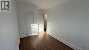 Newmarket apartment for rent - A room with a wooden floor and white walls, with a door on the left and a doorway on the right.