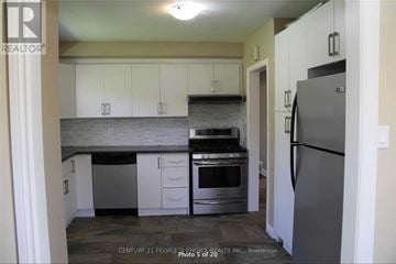 Brampton (Brampton East) apartment for rent - A kitchen with white cabinets and a grey refrigerator.