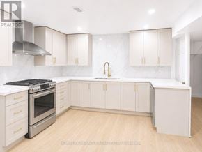 Toronto (West Hill) apartment for rent - A kitchen with white cabinets and a stainless steel range hood.
