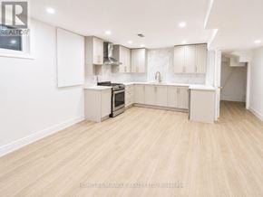 Toronto (West Hill) apartment for rent - A spacious kitchen with wooden flooring and white cabinetry.