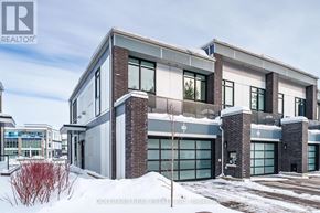 Innisfil townhouse for rent - A modern house with a grey and brown exterior is surrounded by snow.