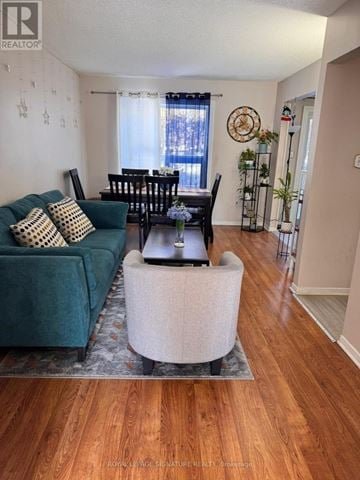 Orangeville townhouse for rent - A living room with a green couch and a wooden floor.
