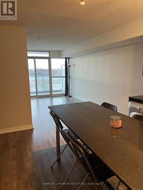 Toronto (Bayview Village) condo for rent - A table with a container on it sits in a room with a view of a parking lot through a glass door.