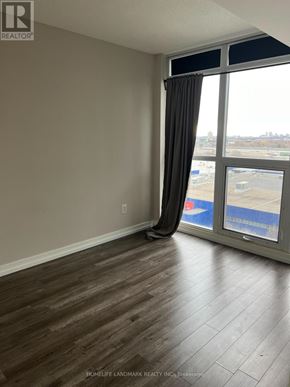 Toronto (Bayview Village) condo for rent - A room with a large window and a view of a parking lot.
