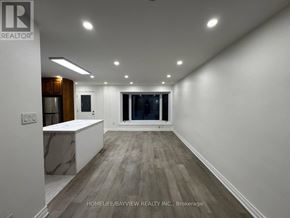 Newmarket (Bristol-London) apartment for rent - A spacious room with wooden flooring and white walls, featuring a kitchen area with a countertop and cabinets.