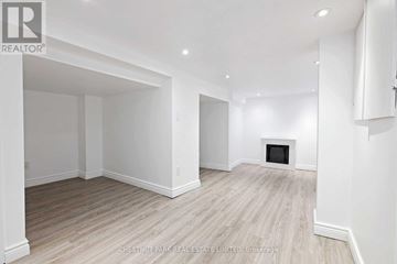 Toronto (Weston) apartment for rent - A spacious room with wood flooring and white walls.