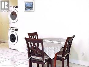 Burnaby apartment for rent - A white washing machine sits next to a table with two chairs.