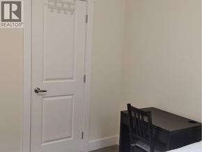 Burnaby apartment for rent - A white door is next to a black desk with a chair.
