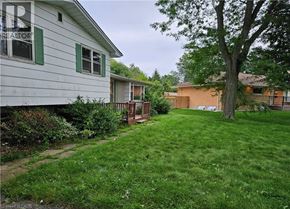 Ancaster apartment for rent - A white house with green shutters and a tree in the yard.