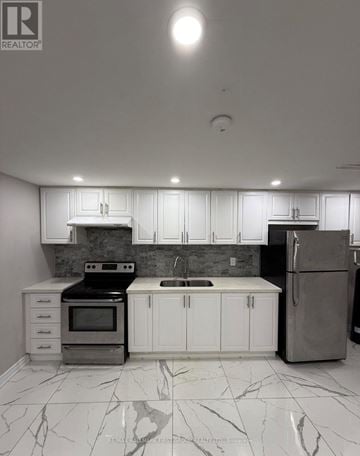Pickering (Brock Ridge) apartment for rent - A kitchen with white cabinets and marble flooring.
