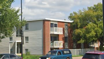 Edmonton apartment for rent - A blue car is parked in front of a building.