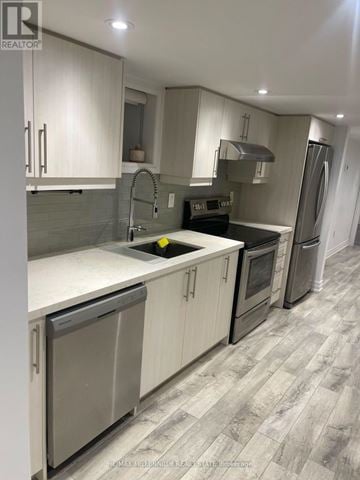Toronto (Dovercourt-Wallace Emerson-Junction) apartment for rent - A modern kitchen with white cabinets and a grey floor.