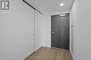 Ottawa condo for rent - A room with a black door and a wooden floor.