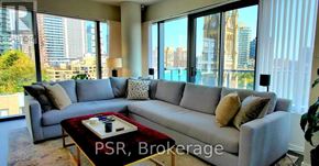 Toronto (Church-Yonge Corridor) condo for rent - A living room with a grey sofa and a coffee table in front of a large window.